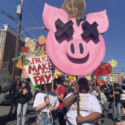 Members of Philly YCL hold colorful signs as part of a parade, one of which reads "Philly YCL, Make the Rich Pay."